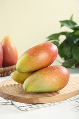 Colorful Ripe Guangxi Mangoes on Wooden Plate - Fresh Tropical Fruit Display