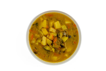 Traditional cucumber soup with potatoes, carrots, and spices in white bowl, top view, homemade Polish cuisine.