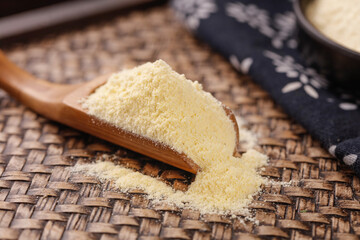 Freshly Ground Glutinous Rice Flour in Wooden Spoon on Bamboo Mat for Traditional Asian Cooking