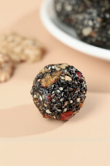 Handmade Energy Ball with Black Sesame Seeds and Nuts Closeup on Wooden Board
