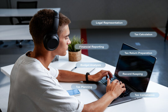 Young man studying finance topics while using a laptop in a modern workspace