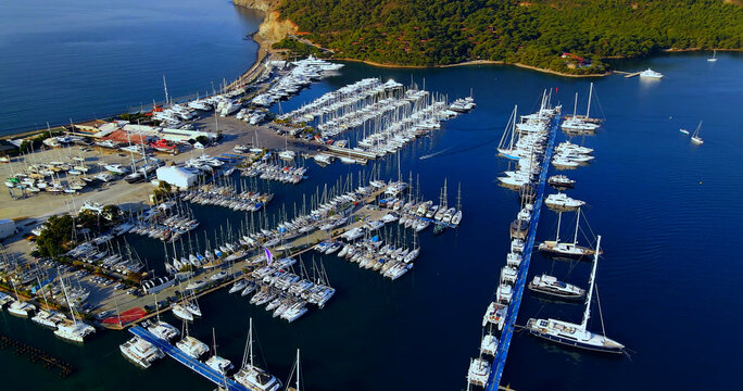 Aerial view of the vast marina with moored sailboats and driveways for cars
