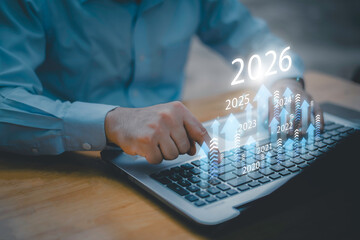 Businessman drawing digital growth arrows and bar graph with 2026 target. Futuristic concept for business goals, technology strategy, data-driven planning, success and innovation.