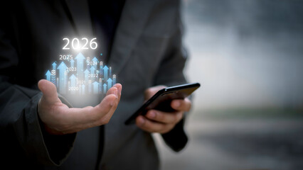 Businessman drawing digital growth arrows and bar graph with 2026 target. Futuristic concept for business goals, technology strategy, data-driven planning, success and innovation.