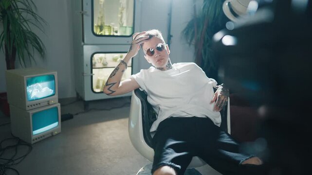 Trendy cool guy posing for camera in studio, self-confidence and self-expression . Tattoos on arms and face for show authenticity and diversity, stay yourself and be unique, modern fashion for youth