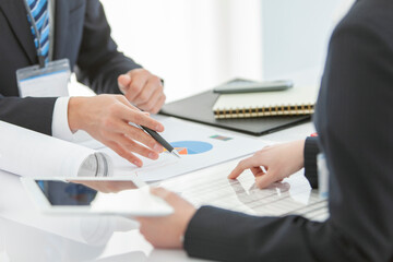 資料を見せて打ち合わせをするビジネスマンとビジネスウーマン 