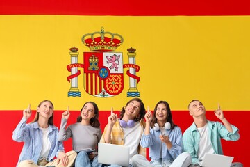 Group of students pointing at something against flag of Spain