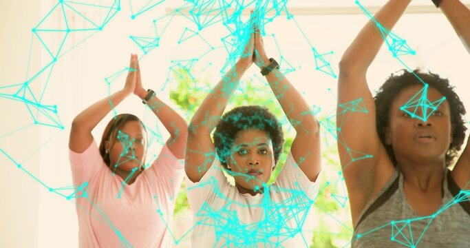 Performing three midlife women in activewear raising palms above heads at gym, with digital overlay