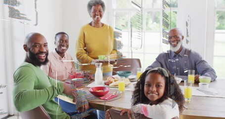 Eating multi-gen family sitting at wooden table at home, wearing yellow sweater with AR overlays