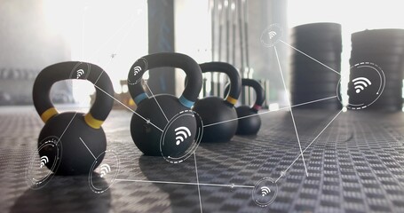 Displaying kettlebells with colored bands sitting on gym flooring, with wireless overlay © vectorfusionart