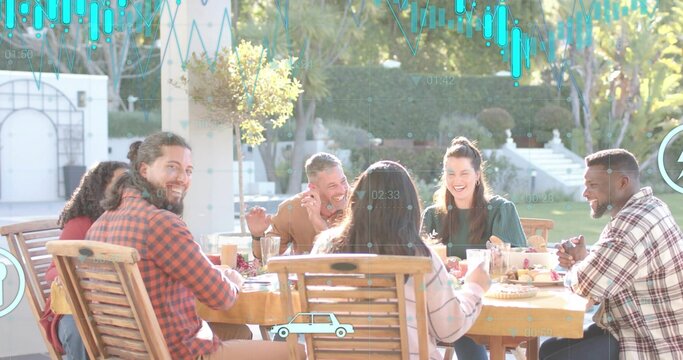 Laughing six adults sharing meal on backyard patio, wearing casual clothes, wooden table