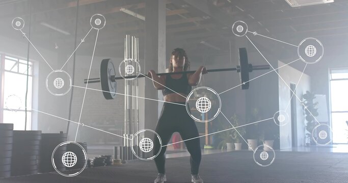 Holding loaded barbell, woman lifter performing front squat in warehouse gym, in black gear - Powered by Adobe