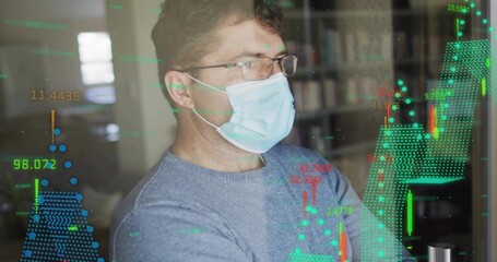 Mature man wearing surgical mask glasses blue sweater studying candlestick charts at desk monitor