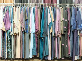 Mix colors Traditional Arabic abayas and clothing are displayed for sale at a cloth store in Souq Waqif, featuring intricate designs and cultural elegance.