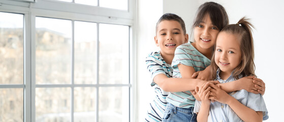 Cute little friends hugging in room
