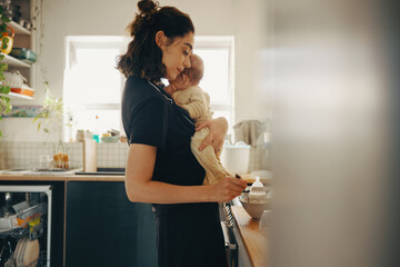 Mother comforting baby in the kitchen