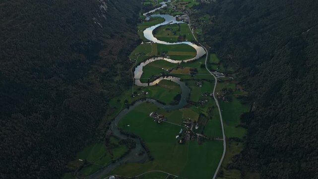 Winding river flows through green fields near Stryn, Norway, aerial view