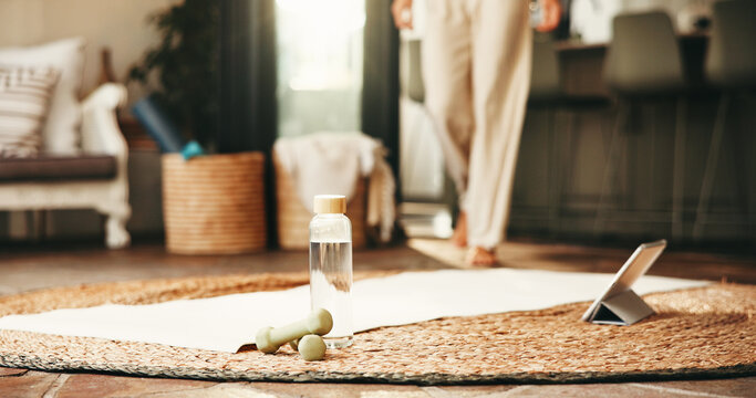 Water, dumbbells and person with tablet for fitness in home with online tutorial for workout or health. Digital technology, bottle and weights for exercise with yoga mat for equipment in apartment.