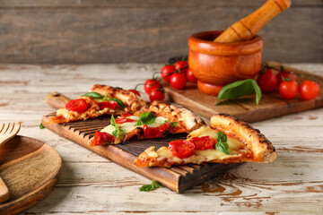 Board with slices of tasty pizza Margarita on table