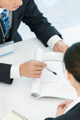 資料を見せて打ち合わせをするビジネスマンとビジネスウーマン 