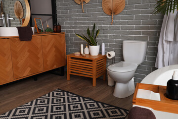 Interior of modern bathroom with bathtub and toilet bowl