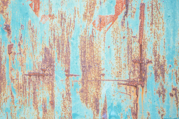 Weathered blue wooden surface with peeling paint showing rich textures and colors in natural light