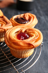 Grid of tasty cruffins with jam on black background