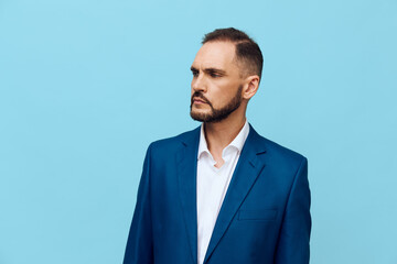 A professional man in a blue suit stands against a solid light blue background, projecting confidence and focus, conveying corporate elegance and calm leadership.
