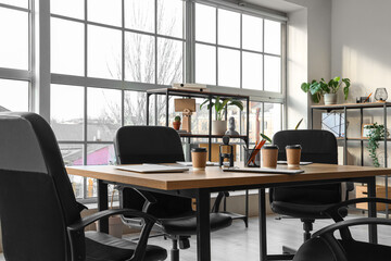 Table with coffee cups prepared for business meeting in office