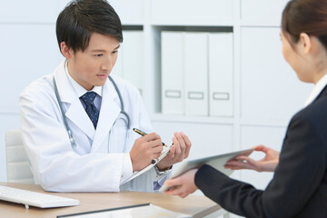 Obraz premium 打ち合わせをする医師とビジネスウーマン 
