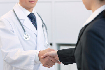 医師と握手するビジネスウーマン 