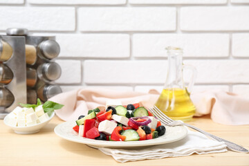 Plate of healthy vegetable salad with fork and napkin on wooden table