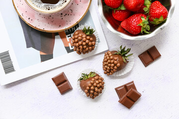 Chocolate covered strawberries with cup of coffee and bowl of fresh berries on white background