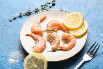 Plate with tasty boiled shrimps, lemon and rosemary on blue background