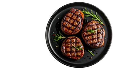 Three steaks on black plate, grilled and garnished beautifully