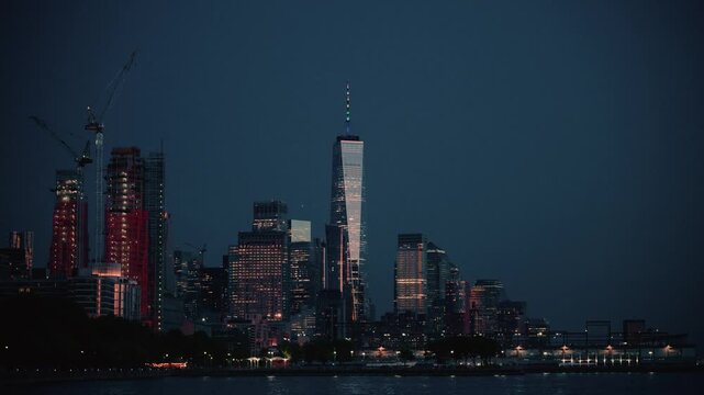 Downtown Manhattan at Dusk with Glowing Skyscrapers and Waterfront Reflections