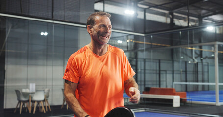 Laugh, sports and mature man for padel game, tournament and competition on indoor court. Tennis, happy athlete and person with racket for training, exercise and workout for challenge and fitness