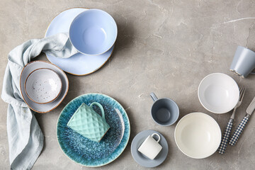 Set of clean dishes, cutlery and napkin on grunge background