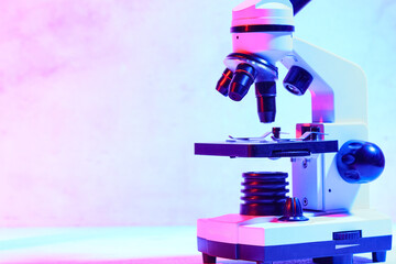 Modern microscope in laboratory on blue background