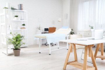 Blurred view of medical office with desks, couch and shelf units
