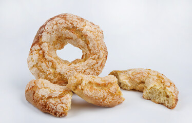 Whole and broken ring shaped cupcake with sugar sprinkles on white background.
