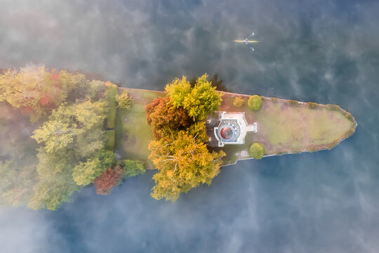 Aerial view of Temple Island stands serene amidst the Thames, its white structure contrasting with the autumnal foliage, Henley-on-Thames, Oxfordshire, England, United Kingdom.