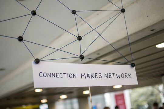 Overhead display showing a network of dots and lines with a Connection Makes Network sign