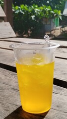 Cold glass of fresh lemonade drink with yellow lemon and ice isolated on white background