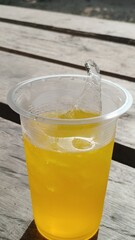 Glass of fresh yellow lemonade drink with ice and citrus fruit slices isolated on white background