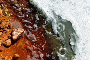 Acidic mine residual water drainage, flowing into decanting pond
