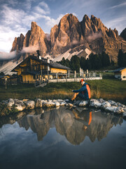 man sitting at mountain lake in the dolomites