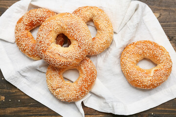 Tasty bagels with sesame seeds on wooden background