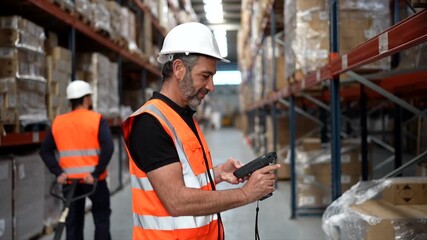 Warehouse supervisor scanning packages with barcode scanner - Powered by Adobe