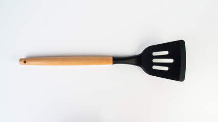 Hand holding kitchen utensils on white background